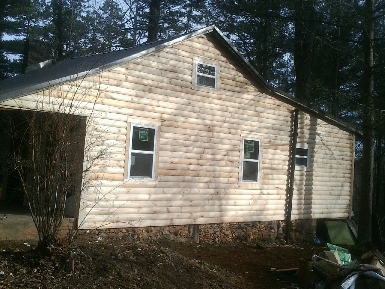 New log siding and dark metal roofing on a gable end in Fairport
