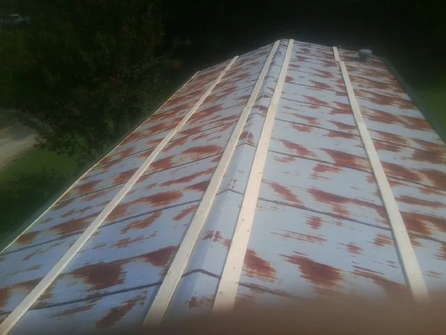 Rusted metal roof panels with new wood purlins before replacement — Storm Damage Roof Repair in Fairport by Roofing Brothers