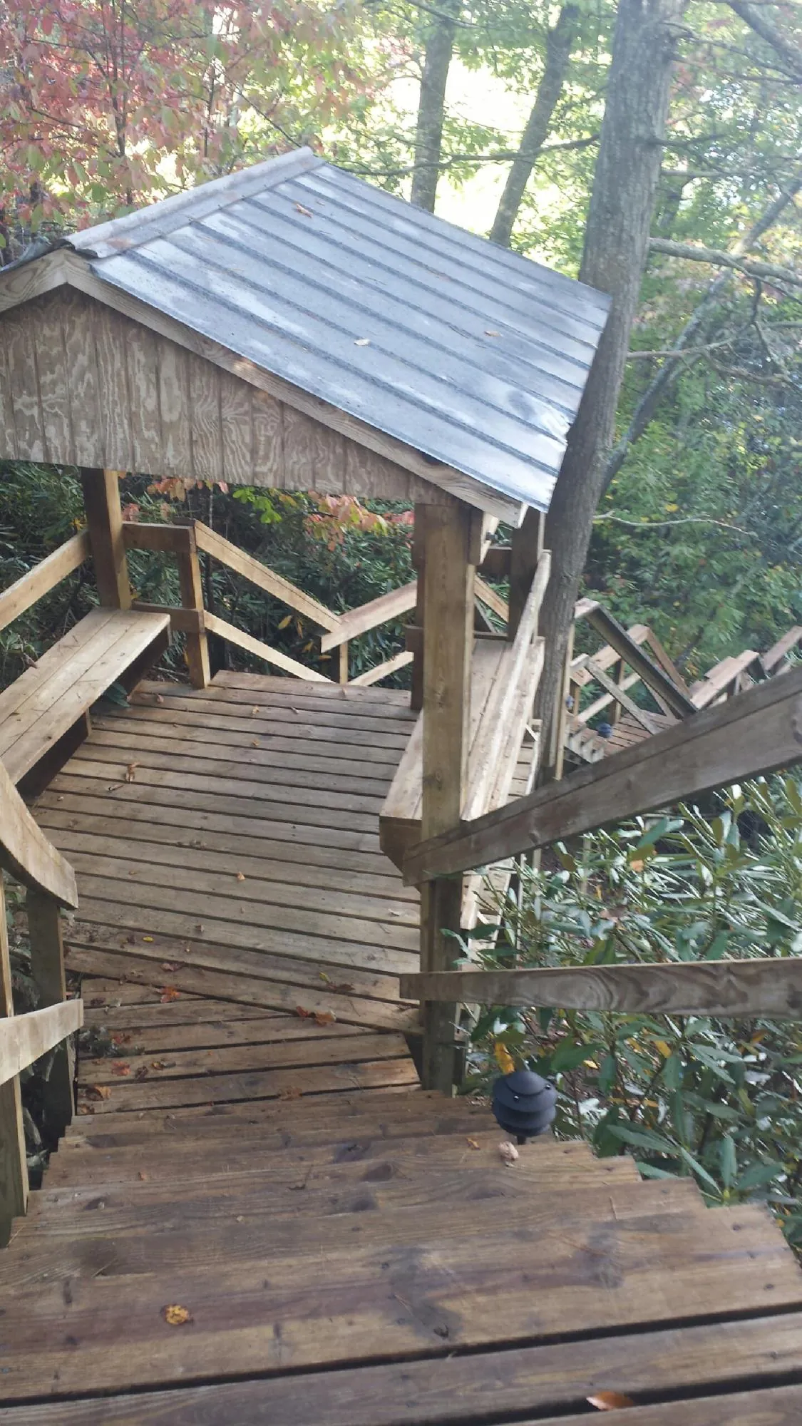 Metal roofed shelter over wooden steps on a wooded walkway — Skylight Repair & Installation work by our crew in Fairport